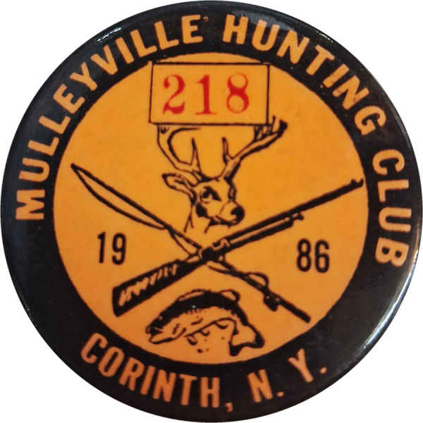 The 1986 Mulleyville Hunting Club pin, Corinth N.Y., number 218, showing a whitetail buck over a crossed rifle and fishing rod with a fish below